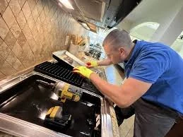 Technician inspecting a kitchen cooktop
